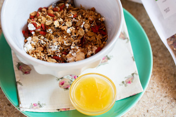 Healthy food background with homemade oatmeal granola or muesli with cottage cheese on white bowl and honey for healthy morning breakfast, top view, copy space. Breakfast and healthy concept.