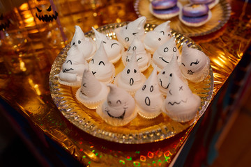 White souffle in the shape of ghosts on a gold plate