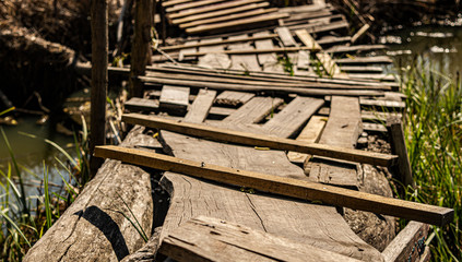 handmade wooden bridge across the water on a sunny day