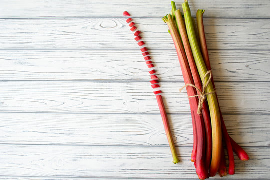 Rhubarb stems with a chopped one on white background