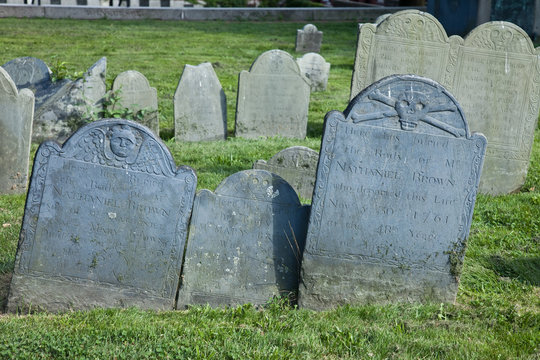 Very old leaning granite tombstones in a graveyard