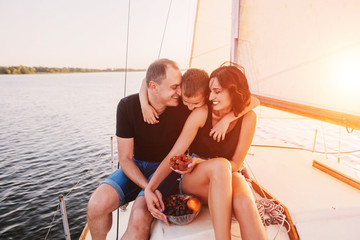 Happy family relaxing on sailboat