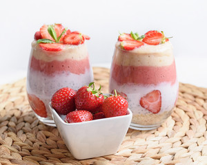 Glass of sweet delicious homemade layered smoothie dessert made from fruits and berries. delicious Strawberry banana milkshake, vegan raw food. Selective focus. Chia pudding