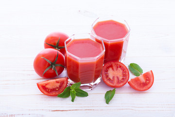 Tomato juice and tomato vegetables on wood texture