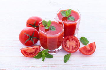 Tomato juice and tomato vegetables on wood texture