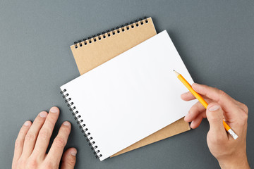 Notebook clear page and male hands with pencil.