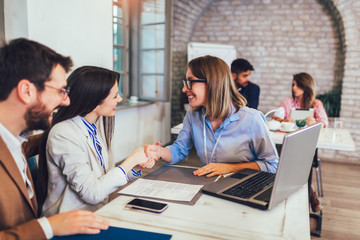 Fototapeta premium Young couple signing a contract on a meeting with investment agent in the office.