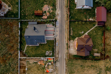 Aerial top view of a house with paved yard with green grass lawn with concrete foundation floor