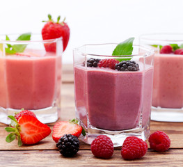 Drink smoothies summer strawberry, blackberry, raspberry on wooden table.