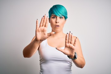 Young beautiful woman with blue fashion hair wearing casual t-shirt over white background Moving...