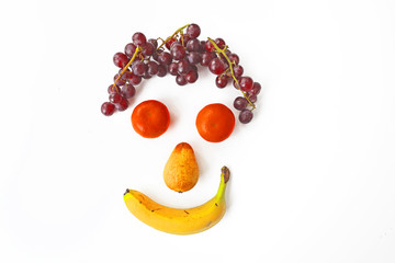 Funny smiling face made of fruit on a white background