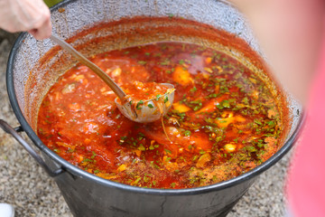 borsch in a huge cauldron - traditional beetroot soup on the picnic