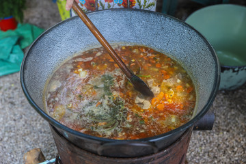 borsch in a huge cauldron - traditional beetroot soup on the picnic