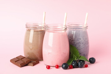 Blueberry, strawberry and chocolate milkshakes on pink background. Delicious drink