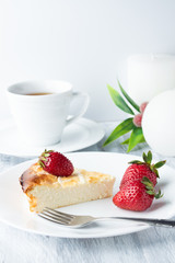 Cheesecake with strawberries on a white plate.