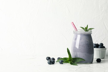 Glass of berry milkshake on white table. Summer drink