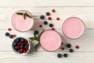 Obraz na płótnie Canvas Delicious berry milkshakes on wooden table. Summer drink