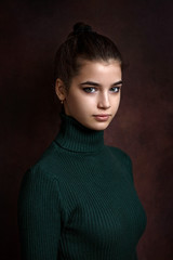a girl in a green sweater and skirt on a dark background