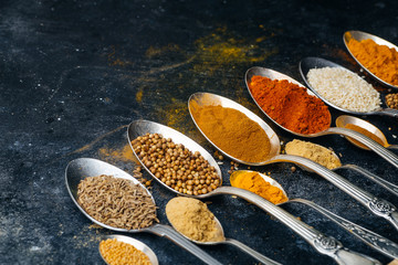 Spices in spoons background. Varieties of spices (turmeric, pepper, chili, coriander, cinnamon) and peppers for cooking. Culinary food concept.