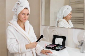 Woman doing herself makeup at home in the bathroom