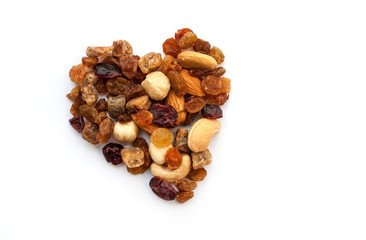 Heart made of nuts and dried fruits on a white background with copy space.