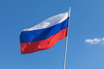 Flag of Russia developing against the blue sky