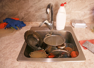 Dirty dishes in the sink. No one likes to wash dishes. Dirty plates, forks, and cups accumulate in...