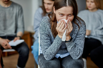 young caucasian woman alcohol addict cry from hopelessness, ask for help and advice how to get rid of alcoholism. at meeting