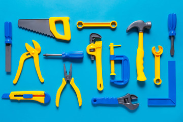 Toys background. Top view of toy tools on blue background