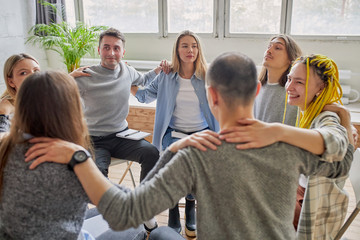 positive spending time of alcoholics in the club, young people sit in circle hugging each other