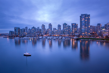 Obraz premium Vancouver downtown architecture and boat with water reflections at dusk
