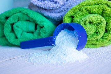 Scattered washing powder near the washed towels. House cleaning