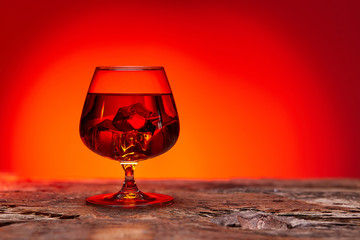 glass of whiskey on wooden table , red tint atmosphere, time of relax with whisky