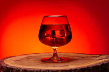 glass of whiskey on wooden table , red tint atmosphere, time of relax with whisky