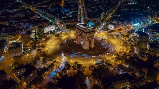 night time illumination paris city center triumph arch traffic circle street aerial timelapse panorama 4k france