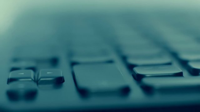 On the black keyboard, the finger presses the keys Shift, Ctrl, Alt Gr, Back. Macro. Closeup. Shallow depth of field. The camera moves around. Slow mo, slo mo, slow motion, high speed camera