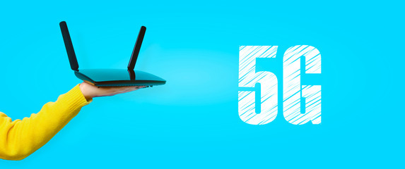 black wifi router on hand over yellow background, 5G concept, panoramic image