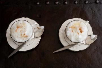 Dos tazas de café espumoso con cucharas 
