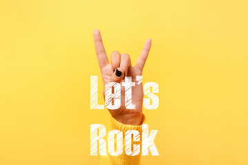 rock and roll sign over trendy yellow background, let's rock concept