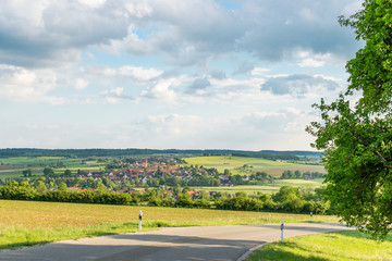 Die Straße auf dem Foto führt vom Hesselberg hinunter nach Gerolfingen in Bayern (Deutschland).