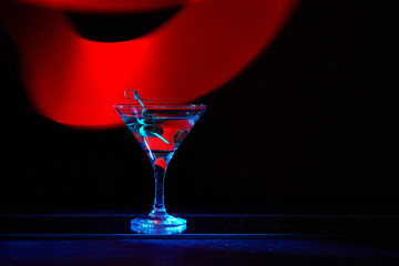 Martini cocktail drink splash with ice cubes in neon iridescent . Minimal night party life concept.