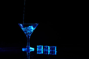 Martini cocktail drink splash with ice cubes in neon iridescent . Minimal night party life concept.