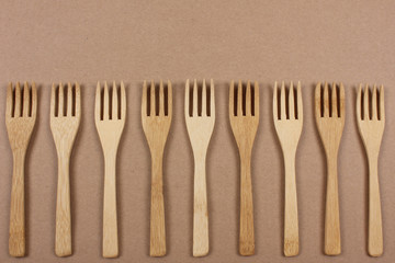 Wooden forks. Eco friendly disposable kitchenware utensils on paper background. Eco friendly concept. Top view. Copy space.