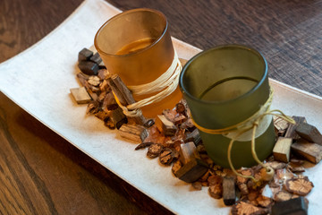 Beautiful decor or interior in a cafe or restaurant. Two glass glasses stand on a white tray, decorated with wooden sawdust.