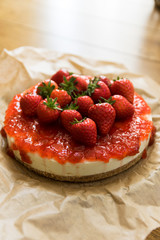 Homemade cheesecake with strawberries on a wooden table