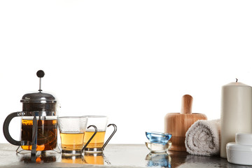 Tea ceremony. Tea party. Glass mugs with tea. Kettle with infusion. Candle and accessories. Copy space. White backdrop