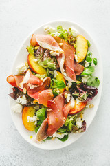 Summer salad with ham, peaches and cheese