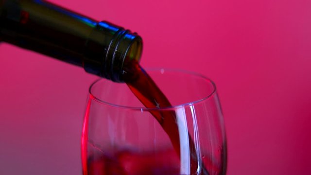 Girando o vinho na ta&ccedil;a com o fundo rosa