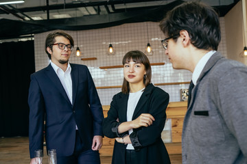 Group of business people in a meeting standing grouped in a office