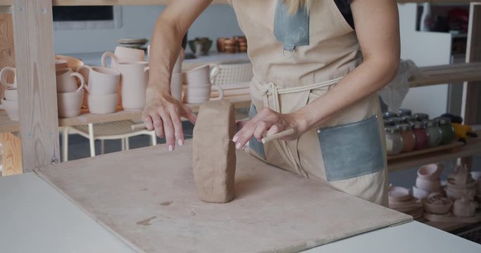 Female potter cutting piece of pottery clay